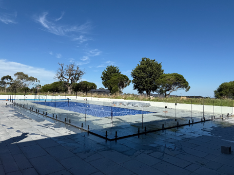 Wide glass fenced pool